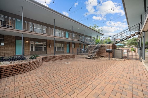 a brick courtyard with a staircase in front of a building