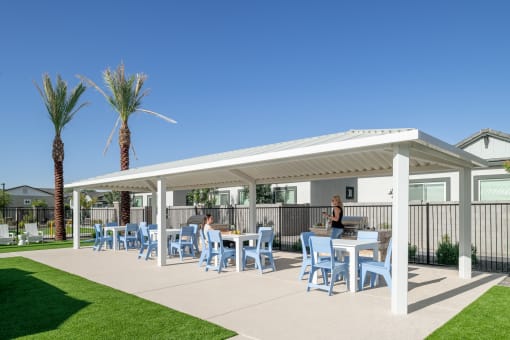 a rendering of a patio with tables and chairs under a white roof