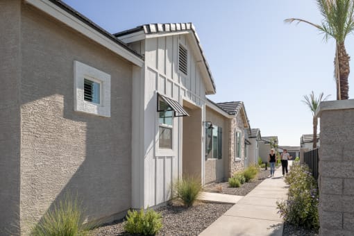 people walking down a sidewalk in front of houses
