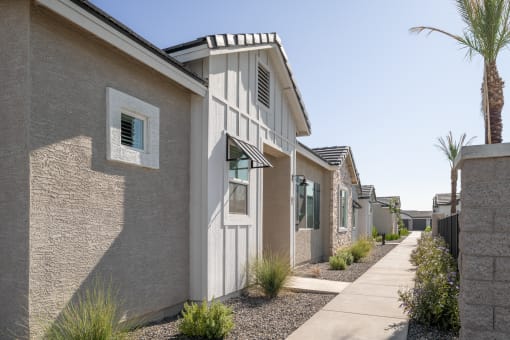 a row of white and gray houses with a sidewalk