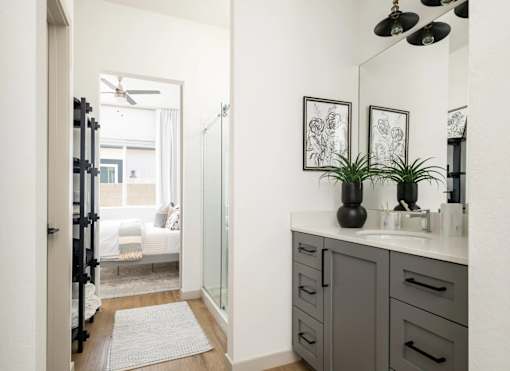 A bathroom with a white sink and a mirror above it.