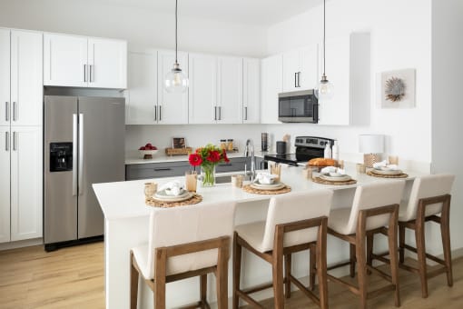 a kitchen with a large island with a white counter top
