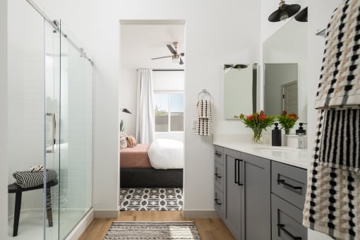a bathroom with a shower and a bedroom with a bed
