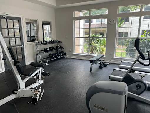a gym with weights and other exercise equipment and windows