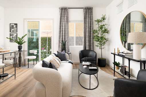 A modern living room with a large grey sofa and a black chair.