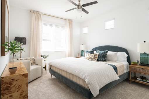 A bedroom with a large bed and a ceiling fan.