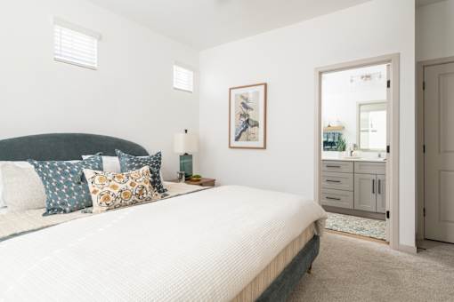 A bedroom with a large bed and a cabinet with a mirror.