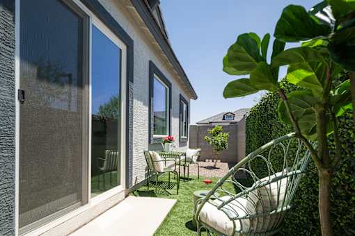 A patio with a chair and a table is shown.