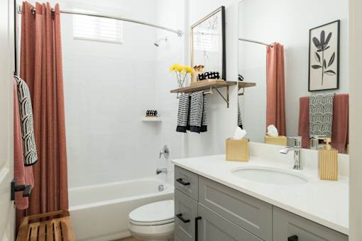 A bathroom with a white sink and a white toilet.