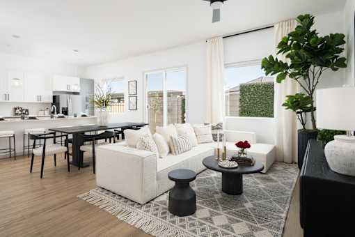 A modern living room with a black coffee table and a white sofa.