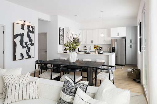 A modern dining room with a black table and chairs.