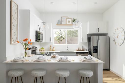 A modern kitchen with a white color scheme and a large island in the center.