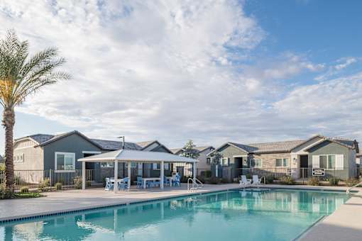 A swimming pool in front of a row of houses.