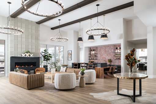 A modern living room with a fireplace and a variety of seating options.