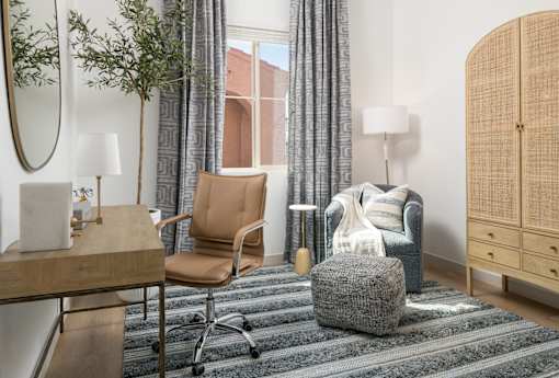 A room with a chair, a table, a couch, and a rug.
