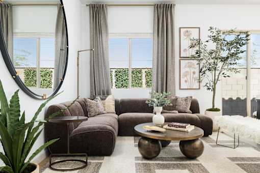 A living room with a brown couch, a coffee table, and a potted plant.