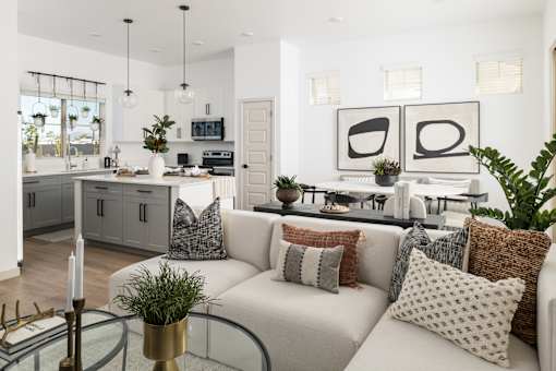 A modern living room with a white sofa and a glass coffee table.