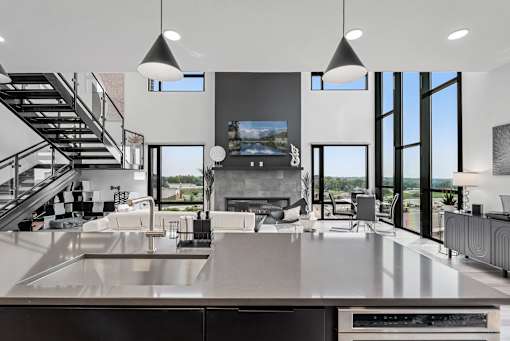 A modern kitchen with a stainless steel countertop and a television above it.