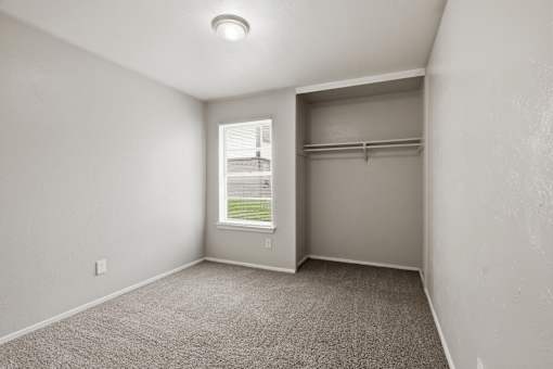 A room with a window and a closet.