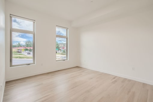 a bedroom with hardwood floors and white walls