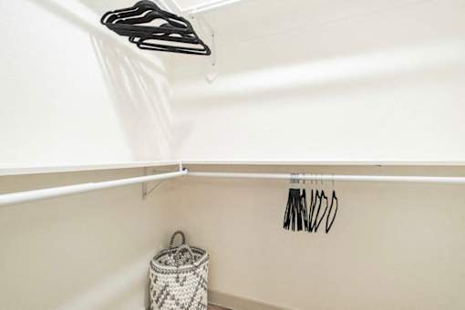 A white laundry basket sits under a clothes dryer.