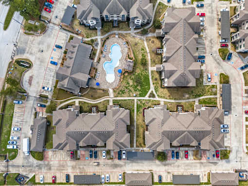 A bird's eye view of a residential area with houses and a swimming pool.