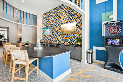 A room with a dartboard and a blue wall.