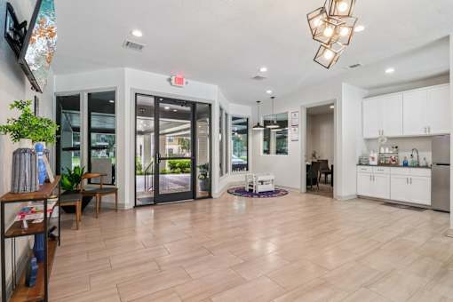 A spacious living room with a kitchen area in the background.