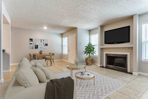 A living room with a couch, coffee table, and fireplace.