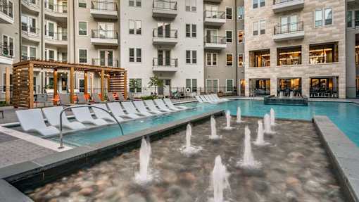A pool with a fountain in the middle of it.