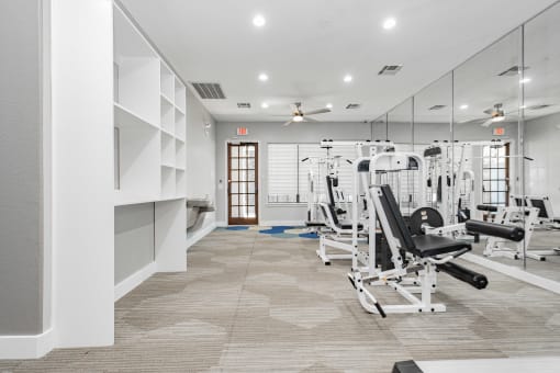 a gym with cardio machines and weights on the floor