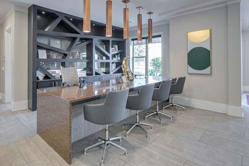 A modern kitchen with a long island and chairs.