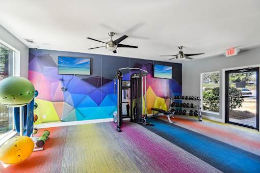A colorful gym with a slide and exercise equipment.