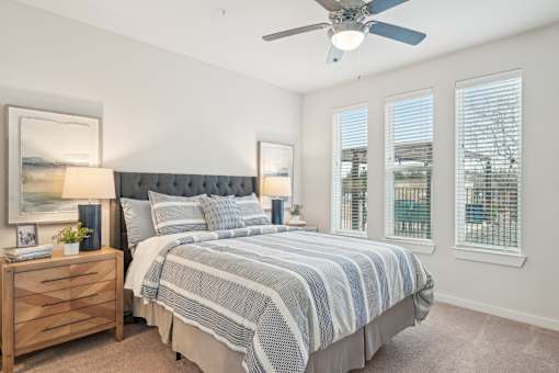 A bedroom with a large bed and a ceiling fan.