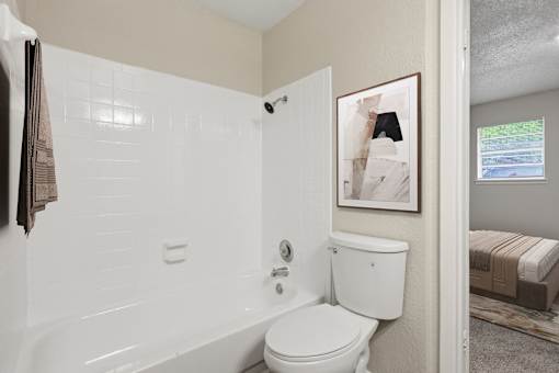 A white bathroom with a toilet, sink, and shower.