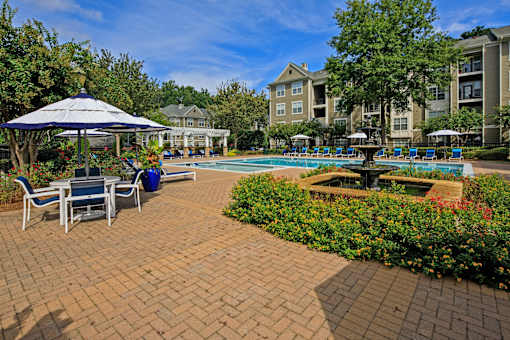 A pool area with a gazebo and chairs.