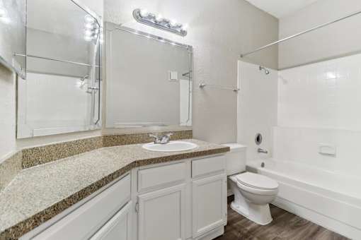 A white bathroom with a sink, toilet, and bathtub.