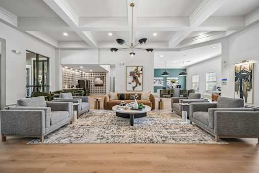 A spacious living room with grey couches and a patterned rug.