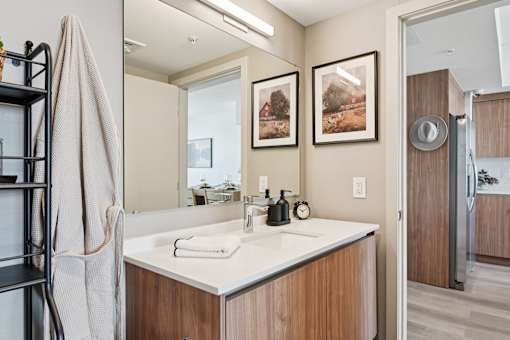 A bathroom with a white sink and a towel rack.