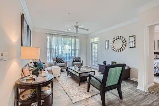 A living room with a dark wood floor and furniture.