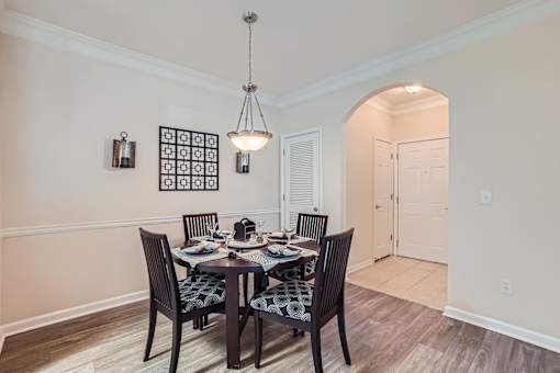 A dining room with a table set for four.