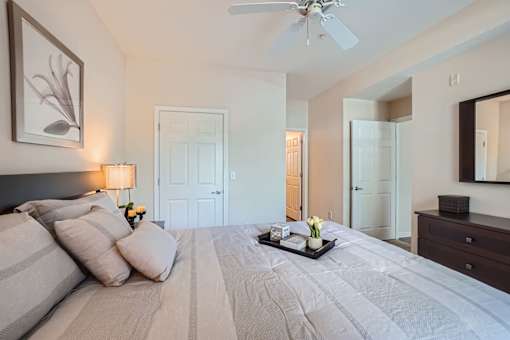 A bedroom with a large bed and a ceiling fan.