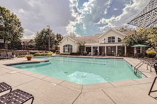 A large swimming pool in front of a house.