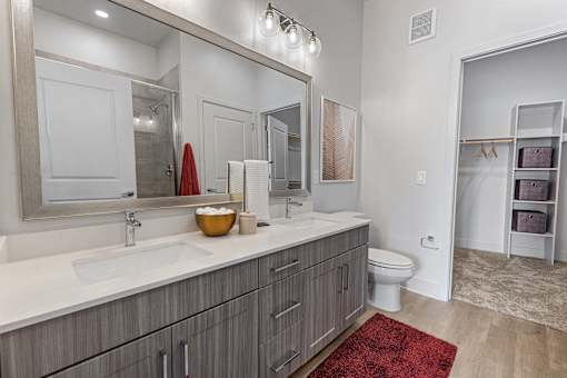 A bathroom with a red rug in front of a sink.