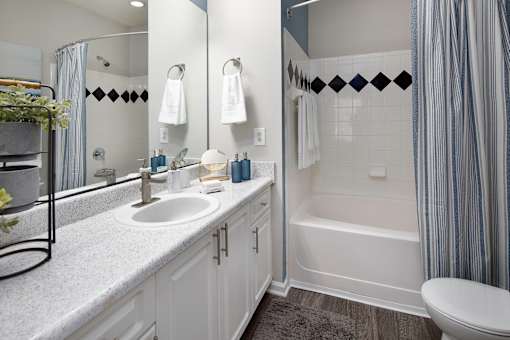 A white bathroom with a sink, toilet, and bathtub.