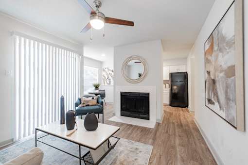A living room with a fireplace and a painting on the wall.