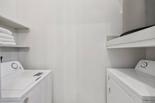 A white washing machine and dryer in a laundry room.