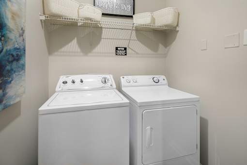 A white washing machine and dryer in a small laundry room.