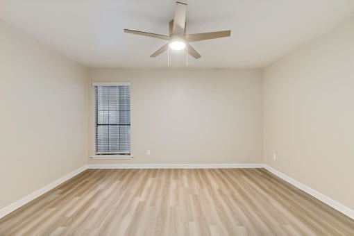 a bedroom with hardwood floors and a ceiling fan