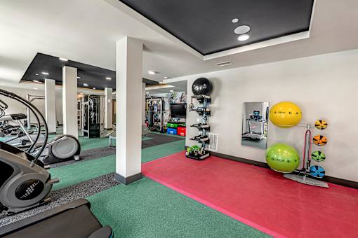 A gym with a red mat in the middle of the room.